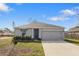 Charming single-story home featuring a two-car garage, freshly painted exterior, and a well-manicured front lawn at 408 Danube Dr, Poinciana, FL 34759