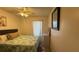 Well-lit bedroom featuring ceiling fan, floral comforter and artwork, and neutral-toned walls at 414 Otter Creek Dr, Kissimmee, FL 34743