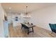 Bright and airy dining room with a wooden table, teal chairs, modern light fixture, and white walls and trim at 452 Diamond Dove Cv, Winter Springs, FL 32708