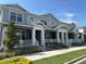 View of blue townhomes showcasing covered porches, white railings, and meticulously landscaped front yards at 452 Diamond Dove Cv, Winter Springs, FL 32708