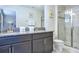 Bathroom with double sink vanity, granite countertop, and a glass-enclosed shower at 4768 Kings Castle Cir, Kissimmee, FL 34746