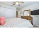 Comfortable bedroom features a ceiling fan, TV, and a wooden dresser with large mirror at 4768 Kings Castle Cir, Kissimmee, FL 34746