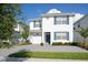 Charming two-story home showcasing blue shutters, a gray driveway, and well-maintained landscaping at 4768 Kings Castle Cir, Kissimmee, FL 34746