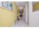 Spacious hallway with yellow accent wall, tile floors, and decorative elements at 4768 Kings Castle Cir, Kissimmee, FL 34746