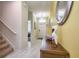 Bright hallway with tile flooring, decorative mirror, and stairs leading to the upper level at 4768 Kings Castle Cir, Kissimmee, FL 34746