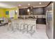 Kitchen island with dark wood cabinetry, stone counters, stainless appliances and seating at 4768 Kings Castle Cir, Kissimmee, FL 34746