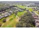 Expansive aerial view of a golf course community with homes nestled among lush greenery and a water feature at 538 Via Vitale Ct, Kissimmee, FL 34759