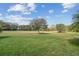 Lush green golf course, mature trees, and blue skies create a serene backyard backdrop at 538 Via Vitale Ct, Kissimmee, FL 34759