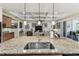 Kitchen island featuring granite countertop and stainless steel sink and views of the living room at 538 Via Vitale Ct, Kissimmee, FL 34759