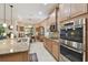 Modern kitchen featuring stainless steel appliances, wood cabinets, breakfast bar, and tile flooring at 538 Via Vitale Ct, Kissimmee, FL 34759