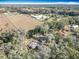 Aerial view capturing the property's layout with its house, surrounding trees, and nearby fields at 6189 Nw 68Th St, Ocala, FL 34482