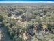 Sweeping aerial shot showcasing the house nestled among trees and the expansive wooded landscape at 6189 Nw 68Th St, Ocala, FL 34482