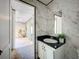 Bathroom featuring marble-look walls, black granite countertop, and white cabinets at 6189 Nw 68Th St, Ocala, FL 34482