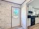 Well-lit entryway leading into a modern kitchen with white cabinets and stainless steel appliances at 6189 Nw 68Th St, Ocala, FL 34482