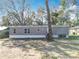 Gray house with white trim surrounded by a grassy area and scattered trees at 6189 Nw 68Th St, Ocala, FL 34482