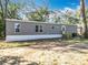 Gray house with white trim surrounded by a grassy area and scattered trees at 6189 Nw 68Th St, Ocala, FL 34482