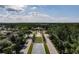 An aerial view reveals a clock tower and community's manicured green spaces, all set against a backdrop of mature trees at 6441 Point Hancock Dr, Winter Garden, FL 34787