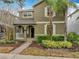 Two-story home featuring lush landscaping, beige shutters and a brick walkway at 6441 Point Hancock Dr, Winter Garden, FL 34787