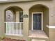 Charming front porch featuring white railings and an arched entryway at 6441 Point Hancock Dr, Winter Garden, FL 34787