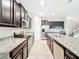 Kitchen with stainless steel appliances, granite countertops, and dark cabinetry, perfect for modern living at 6441 Point Hancock Dr, Winter Garden, FL 34787