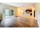 Open-concept living room features wood flooring, sliding glass doors, and a view to the kitchen at 6441 Point Hancock Dr, Winter Garden, FL 34787