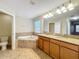 Main bathroom featuring a soaking tub, double vanities, and stylish tiling at 6441 Point Hancock Dr, Winter Garden, FL 34787