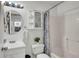 Bright bathroom with a vanity, toilet, shower with stylish curtain and cabinet with shelves at 6921 Long Needle Ct, Orlando, FL 32822