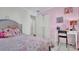 Pink bedroom features a bed, desk, and closet for ample storage at 6921 Long Needle Ct, Orlando, FL 32822