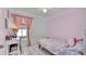 Pink bedroom features a bed, desk, and window with bright light at 6921 Long Needle Ct, Orlando, FL 32822