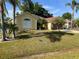 Charming single-story home featuring a well-manicured lawn, a two-car garage and lush tropical landscaping at 701 Swallow Ln, Poinciana, FL 34759