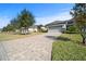 Long driveway leading to a beautiful home with a lush, green lawn and mature trees on a sunny day at 732 Aldenham Ln, Ormond Beach, FL 32174