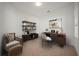 Office featuring a desk with laptop, shelving, chair and ottoman, and natural light from the window at 732 Aldenham Ln, Ormond Beach, FL 32174