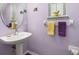 Charming powder room with pedestal sink, decorative mirror, and lavender walls at 826 Lake Evalyn Dr, Celebration, FL 34747