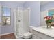 Well-lit bathroom with a glass-enclosed shower, neutral walls, and a toilet, providing a clean and functional space at 826 Lake Evalyn Dr, Celebration, FL 34747