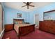 Cozy bedroom featuring blue walls, a ceiling fan, and a dark wood bedroom set, providing a warm and inviting space at 826 Lake Evalyn Dr, Celebration, FL 34747