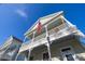 Low angle shows an exterior elevation with a double porch, railings, and American Flag at 826 Lake Evalyn Dr, Celebration, FL 34747