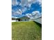 White vinyl fencing surrounds a spacious backyard that features green grass and a covered patio area at 870 Galloway St, Lake Alfred, FL 33850