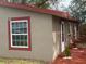 Side view of home showing windows, door, landscaping and stucco exterior at 888 Berkley Rd, Auburndale, FL 33823