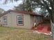 Angled side view of home showing windows, door, landscaping and stucco exterior at 888 Berkley Rd, Auburndale, FL 33823