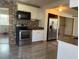 Bright kitchen featuring a stone accent wall, stainless appliances, and white cabinetry at 888 Berkley Rd, Auburndale, FL 33823