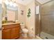 Bright bathroom featuring a wooden vanity with a granite countertop and a glass-enclosed shower at 8949 Candy Palm Rd, Kissimmee, FL 34747