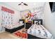 Fun Disney-themed bedroom with two twin beds, a ceiling fan, and cartoon wallpaper at 8949 Candy Palm Rd, Kissimmee, FL 34747