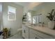 Bright bathroom with a wide mirror, white cabinets, granite countertops, black hardware, and stylish decor at 899 Asterfield Ln, Deland, FL 32720