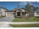 Inviting single-Gathering home with a well-manicured lawn, a two-car garage, and decorative landscaping at 899 Asterfield Ln, Deland, FL 32720