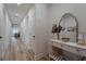 Long hallway with wood floors leads to a bright living area, showcasing a modern console table at 899 Asterfield Ln, Deland, FL 32720