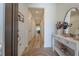 Bright hallway with hardwood floors, white walls, and a decorative table with mirror at 899 Asterfield Ln, Deland, FL 32720