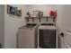 Modern laundry room with front-load washer and dryer and a wall-mounted shelf for storage at 899 Asterfield Ln, Deland, FL 32720