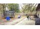 View of a large backyard with a trampoline, lawn furniture, wood fence, and mature trees at 911 Kerry Blvd, Winter Haven, FL 33880