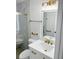 Beautiful bathroom featuring white marble tile with gold hardware, shower stall, vanity, and lighted mirror at 9319 Se 173Rd Hyacinth St, The Villages, FL 32162