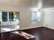 Sunlit living room featuring hardwood floors and a sliding glass door to the outdoors at 9319 Se 173Rd Hyacinth St, The Villages, FL 32162